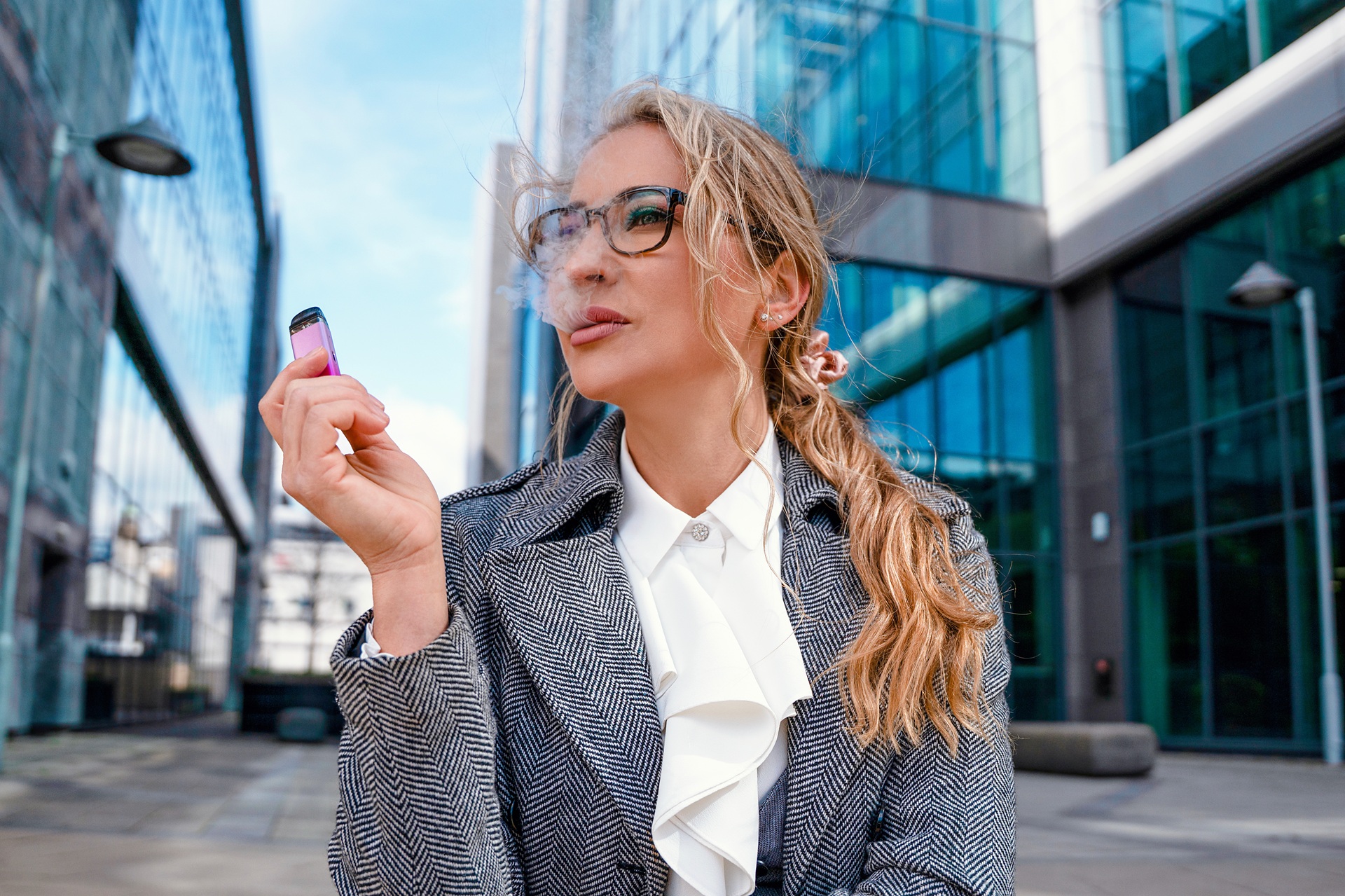 Frau nutzt Einweg-Vape vor Gebäuden | Einweg Vape